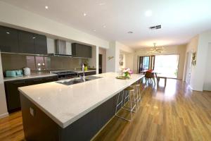 a kitchen with a large island in the middle at Stylish Luxe House For Big Group Near Shopping Center in Point Cook