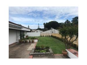 a backyard of a house with a yard with plants at BmyGuest - Sesimbra Country Villa in Sesimbra
