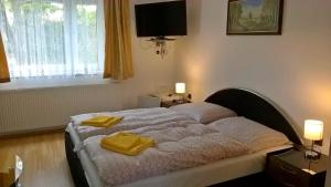 a bedroom with a bed with two yellow towels on it at Penzion Kalina in Tábor