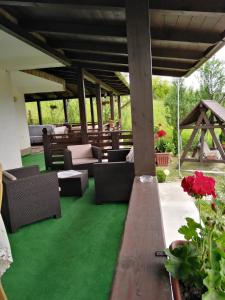 a patio with green flooring and furniture and flowers at Popasul Ioana Oncesti in Onceşti