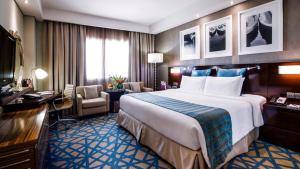 a hotel room with two beds and a desk at Crowne Plaza Dubai Deira, an IHG Hotel in Dubai