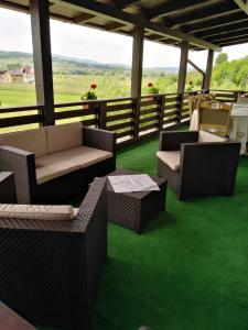 a porch with couches and tables on a green carpet at Popasul Ioana Oncesti in Onceşti