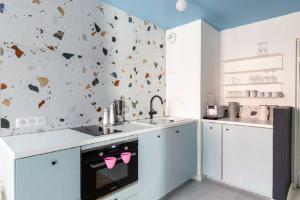 a kitchen with white cabinets and a wall covered in butterflies at T2 L'ArtDéco - Parking - Quartier Vivant in Strasbourg