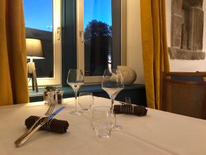 einen Tisch mit drei Weingläsern auf einem Tisch mit einem Fenster in der Unterkunft Auberge Saint Thegonnec in Saint-Thégonnec