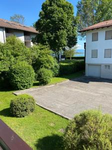 a driveway in front of a white building with bushes at Ferienappartement Simhofer, Seebruck am Chiemsee in Seeon-Seebruck