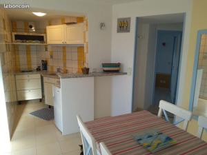 une cuisine avec une table et un comptoir dans l'établissement Appart 2 personnes proche plage de la Fresnaye, à Saint-Cast-le-Guildo 2 autres photos