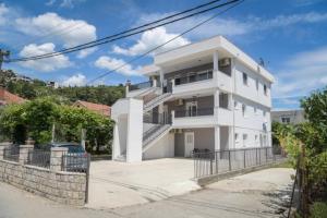 a white house with a staircase in front of it at Apartments Tila in Trebinje