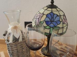 バルドネッキアにあるDeacons Lodgeのワイングラス2杯、テーブルの上のランプ