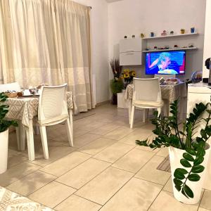 ドームス・デ・マリーアにあるIl Girasoleのリビングルーム(テーブル、椅子、テレビ付)