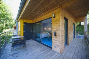 ein Holzhaus mit einem Balkon mit einem Bett darauf in der Unterkunft Domaine de la Résidence - Hôtel, Spa & Restaurant in Moulins-lès-Metz