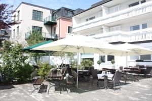an outdoor patio with tables and chairs and umbrellas at Hotel zur Post in Brilon