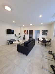 a living room with a black couch and a table at Exchange Hotel Goulburn in Goulburn