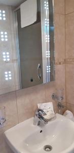 lavabo blanco en el baño con espejo en Trelawne Garden Annexe en Falmouth