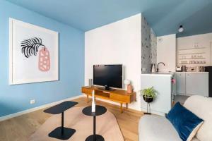 a living room with a couch and a tv at T2 L'ArtDéco - Parking - Quartier Vivant in Strasbourg