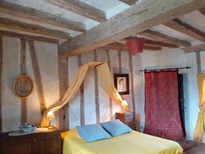 a bedroom with a yellow bed with a wooden ceiling at Chateau de Chémery in Chémery