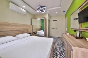 a bedroom with a large white bed and a flat screen tv at Zeytin HOTEL in Kaş +25 photos