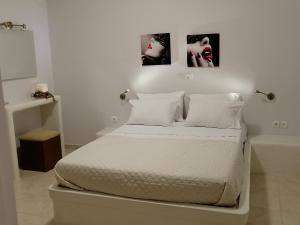 a white bedroom with a bed and a bath tub at Sahara Apartments in Kastraki