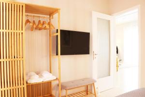 a room with a bed with a tv on a wall at HABITAT Nafplio bnb - Design Apartment in Nafplio