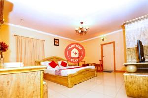 1 dormitorio con 1 cama y TV en Sea Shell Hotel, en Manama