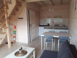 a kitchen and living room with a table and chairs at Domki u Leona in Dąbki