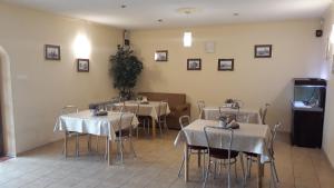 uma sala de jantar com mesas e cadeiras com toalha de mesa branca em Hotel-Restauracja-Bar Rudka em Ostrowiec Świetokrzyski