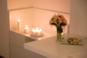 a vase of flowers and candles on a shelf at Dimora Salernum in Salerno