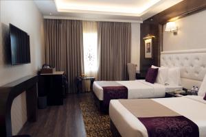 a hotel room with two beds and a television at Zone by The Park, Jammu in Jammu