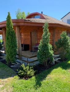 Cabaña de madera con porche y mesa en el patio en Domek Pensjonat Syrena en Krynica Morska
