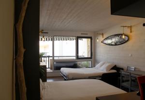 カップブルトンにあるAtlantic Selection - Le studio 48のベッド2台と窓が備わる客室です。