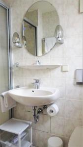uma casa de banho com um lavatório e um espelho em Hotel Zur Traube em Bad Homburg vor der Höhe