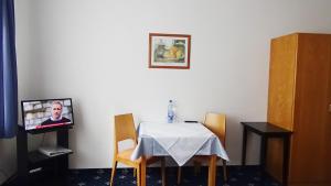 a room with a table and a tv on a wall at Hotel Zur Traube in Bad Homburg vor der Höhe