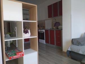 sala de estar con cocina con armarios rojos en Apartments Zlatko, en Pula