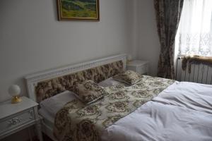 um quarto com uma cama com lençóis brancos e almofadas em Lovecký Apartmán na náměstí ve Frenštátě pod Radhoštěm em Frenštát pod Radhoštěm
