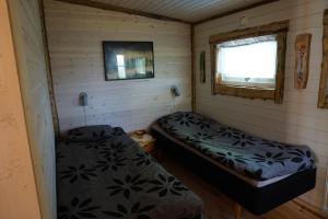 een kleine kamer met 2 bedden en een raam bij Kulppis Bed&Breakfast in Härryda