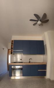 オートラントにあるOtranto Blue Biloのキッチン(青いキャビネット、天井ファン付)