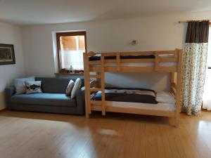 salon z łóżkiem piętrowym i kanapą w obiekcie CHALET VILLA RITA w mieście Tesero