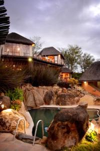 a home with a swimming pool and a house at Addo Dung Beetle Guest Farm in Addo