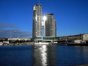 two tall buildings in front of a large body of water at Sea Towers Apartamenty in Gdynia