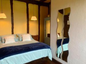 um quarto com uma cama com lençóis azuis e almofadas brancas em Posada de Ziga em Ziga