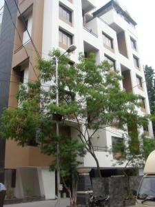 un grand bâtiment blanc avec un arbre devant lui dans l'établissement AR Suites Fontana Bay - Kalyani Nagar, à Pune