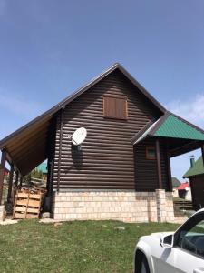 a large building with a white car parked in front of it at Durmitorska kuća in Žabljak