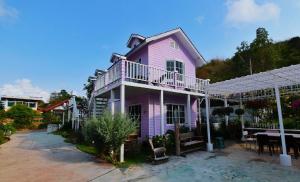 różowy dom ze stołem przed nim w obiekcie Bunny Hill Resort w mieście Chon Buri