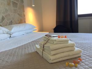 a pile of towels sitting on top of a bed at Ranieri Events and B&B in Casacanditella