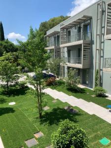 un edificio de apartamentos con un árbol en el patio en HT Hotel Trieste, en Gradisca d'Isonzo