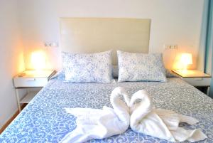twee zwanen zitten op een bed met handdoeken bij Torremolinos:Appartement avec piscine et terrasse in Torremolinos