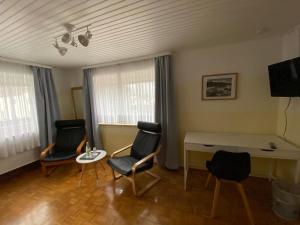 特羅伊赫特林根的住宿－Gasthaus Schlossblick，客厅配有两把椅子和一张桌子