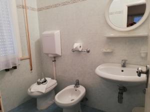 a bathroom with a sink and a toilet and a mirror at Hotel La Bella Vita in Rimini