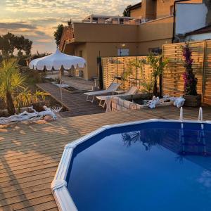 a swimming pool on a wooden deck with a building at Cupido da Simona in Ostellato