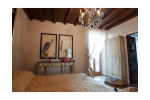 a bedroom with a bed and a chandelier at A PALAZZO FORTEBRACCI B&B in Sutri