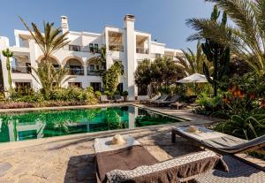 a hotel with a swimming pool in front of a building at Le Riad Villa Blanche in Agadir